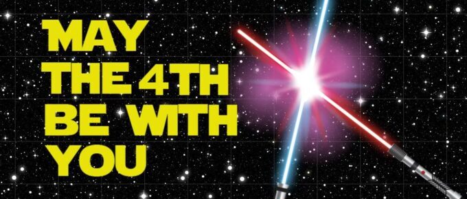 blue light saber clashing with red light saber on a starry background with the words "may the 4th be with you" in yellow